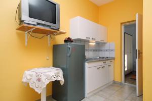 a kitchen with a green refrigerator and a tv on a wall at Seaside holiday house Bibinje, Zadar - 5854 in Bibinje