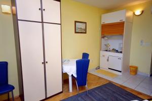 a room with a table and chairs and a kitchen at Apartments by the sea Lokva Rogoznica, Omis - 6004 in Lokva Rogoznica