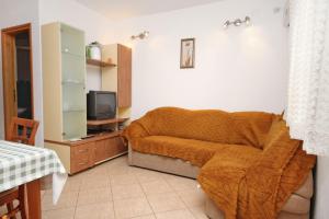 a bedroom with a bed with a blanket and a tv at Apartments with parking space Supetar, Brac - 6037 in Supetar