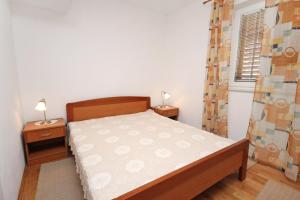 a small bedroom with a bed and two night stands at Apartments with parking space Supetar, Brac - 6037 in Supetar