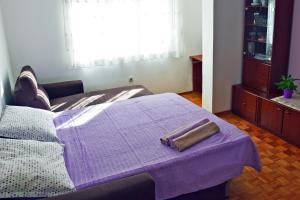 a bedroom with a bed with a purple blanket at Apartments with a parking space Omis - 5988 in Omiš