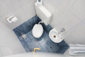 a bathroom with a white toilet and a sink at Apartments with a parking space Omis - 5988 in Omiš