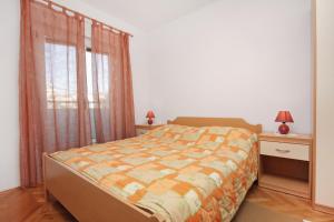 een slaapkamer met een bed en twee nachtkastjes en een raam bij Apartments with a parking space Slatine, Ciovo - 5999 in Slatine