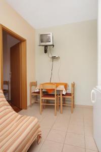 een kamer met een tafel en een tv aan de muur bij Apartments with a parking space Slatine, Ciovo - 5999 in Slatine