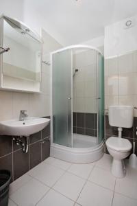 a bathroom with a shower and a toilet and a sink at Apartments by the sea Duce, Omis - 5987 in Duće
