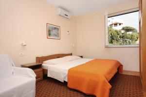 a hotel room with two beds and a window at Apartments by the sea Duce, Omis - 5987 in Duće