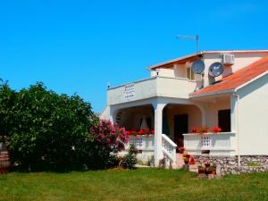 ein weißes Haus mit Blumen auf dem Balkon in der Unterkunft Apartments by the sea Ljubac, Zadar - 5947 in Ljubač