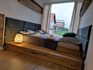 un letto grande in una stanza con una finestra di Domek Roztocze a AdamÃ³w