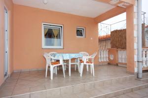 uma mesa e cadeiras na varanda de uma casa em Apartments with a parking space Nin, Zadar - 5936 em Nin