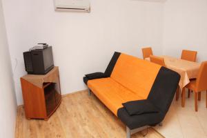 Una sala de estar con una mesa, un sofá y un televisor. en Seaside apartments with a swimming pool Nin, Zadar - 5930, en Nin