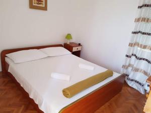 een slaapkamer met een bed met witte lakens en een lamp bij Apartments by the sea Nin, Zadar - 5937 in Nin
