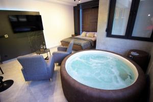 a room with a large tub in the middle of a bedroom at Jacuzzi Sauna SelfCheckIn Mystic in Mostar
