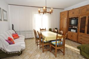 un soggiorno con tavolo, sedie e TV di Apartments by the sea Supetar, Brac - 6040 a Supetar (San Pietro di Brazza)