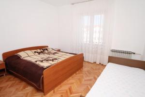 una camera con letto e pavimento in legno di Apartments by the sea Supetar, Brac - 6040 a Supetar (San Pietro di Brazza)