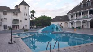 a swimming pool with a slide in front of a hotel at Beautiful Balcony by the Sea Studio in Ocho Rios