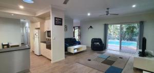 a living room with a couch and a tv and a kitchen at Shelleys House in Rainbow Beach