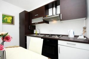 a kitchen with black and white cabinets and a sink at Apartment Drasnice 6051b in Drasnice