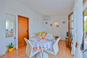 a dining room with a table and white chairs at Holiday house with a parking space Postira, Brac - 6052 in Postira