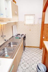 cocina pequeña con fregadero y fogones en Apartments by the sea Arbanija, Ciovo - 6062, en Trogir
