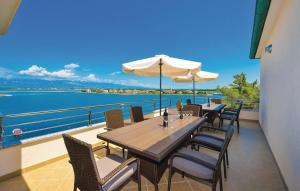 uma mesa com cadeiras e um guarda-sol numa varanda em Seaside apartments with a swimming pool Nin, Zadar - 6153 em Nin