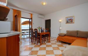 uma cozinha e sala de estar com uma mesa e um sofá em Seaside apartments with a swimming pool Nin, Zadar - 6153 em Nin