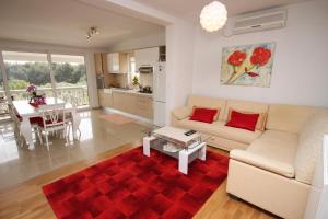a living room with a couch and a red rug at Apartments and rooms by the sea Vodice - 6182 in Vodice +50 photos