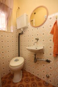 a bathroom with a toilet and a sink and a mirror at Apartments by the sea Tisno, Murter - 6106 in Tisno