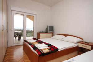 1 Schlafzimmer mit einem Bett und einem Balkon mit einem Tisch in der Unterkunft Apartments with a parking space Sveti Petar, Biograd - 6169 in Sveti Petar