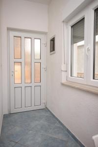 einen Flur mit einer weißen Tür und einem Fenster in der Unterkunft Apartments with a parking space Sveti Petar, Biograd - 6169 in Sveti Petar