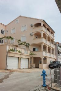 un edificio con dos puertas de garaje y una boca de incendios azul en Apartments by the sea Drage, Biograd - 6171, en Drage