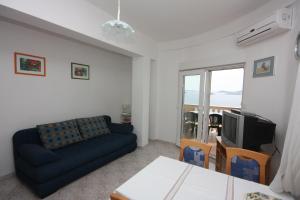 salon z niebieską kanapą i telewizorem w obiekcie Apartments by the sea Drage, Biograd - 6171 w mieście Drage