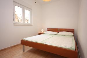 uma cama num quarto branco com uma janela em Apartments by the sea Drage, Biograd - 6171 em Drage