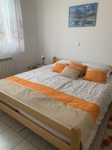 a large bed with an orange and white comforter at Apartment Rabac 7410e in Rabac