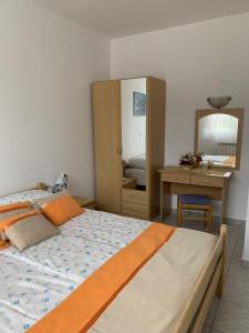 a bedroom with a bed and a desk and a mirror at Apartment Rabac 7410e in Rabac