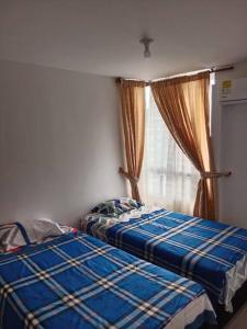 um quarto com 2 camas e uma janela em Apartamento para tu descanso piso 7 em Ricaurte