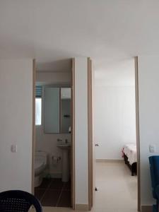 uma casa de banho com um WC, um lavatório e um espelho. em Apartamento para tu descanso piso 7 em Ricaurte