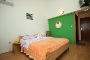 a bedroom with a bed with a green wall at Rooms with a parking space Premantura, Medulin - 7463 in Medulin