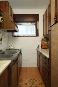 a small kitchen with a sink and a window at Apartments with parking space Rabac, Labin - 7465 in Rabac