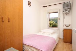 a small bedroom with a bed and a window at Apartments by the sea Duga Luka - Prtlog, Labin - 7491 in Labin