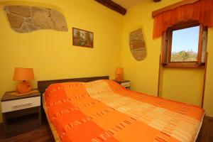 Pulgarija ČepićにあるHoliday house with a swimming pool Cepic, Central Istria - Sredisnja Istra - 7404のベッドルーム1室(オレンジ色のベッド1台、窓付) +12枚の写真