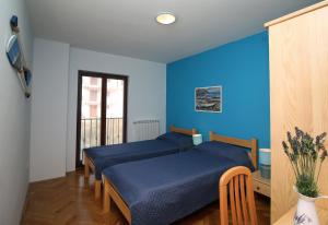 two beds in a room with blue walls at Apartment Rabac 7429a in Rabac