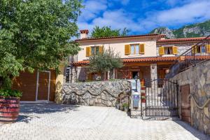 a large house with a stone wall next to a driveway at Holiday house with a swimming pool Kozljak, Central Istria - Sredisnja Istra - 7409 in Plomin