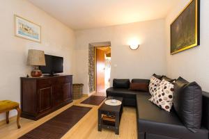 a living room with a black leather couch and a tv at Holiday house with a swimming pool Kozljak, Central Istria - Sredisnja Istra - 7409 in Plomin