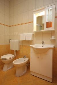 y baño con aseo y lavamanos. en Apartments for families with children Stinjan, Pula - 7423 en Pula
