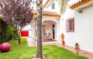 a house with a palm tree in the yard at Nice Home In Matalascaas With Kitchenette in Matalascañas