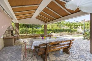 an outdoor patio with a table and two benches at Apartment Vinez 7471a in Labin
