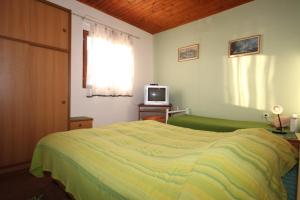 um quarto com uma cama e uma televisão em Apartments by the sea Seget Vranjica, Trogir - 7509 em Seget Vranjica