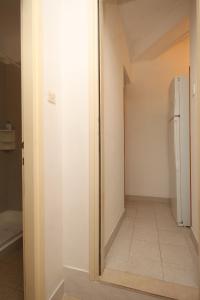 a hallway with a white refrigerator in a room at Apartments by the sea Seget Vranjica, Trogir - 7508 in Seget Vranjica