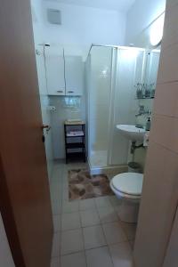 a bathroom with a shower and a toilet and a sink at Apartments by the sea Seget Vranjica, Trogir - 7508 in Seget Vranjica