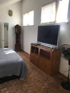 una camera da letto con TV a schermo piatto su un comò di Cheerful 2-Bedroom Cottage Near Eagle Lake a Susanville